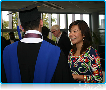 WUAS Director Maggie Feng talking with students at Graduation